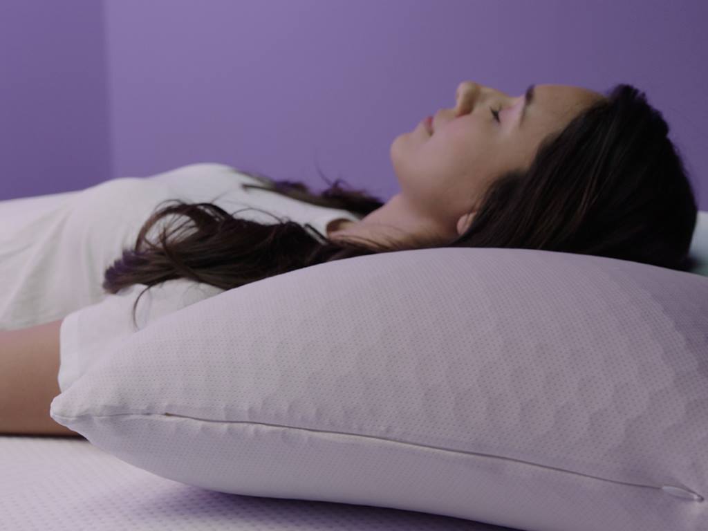 Person sleeping peacefully on Purple Harmony Pillow demonstrating neck alignment